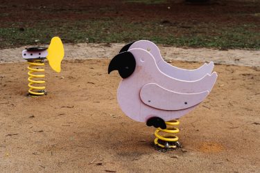 Colorful spring animal rides in an outdoor playground setting, ideal for children.